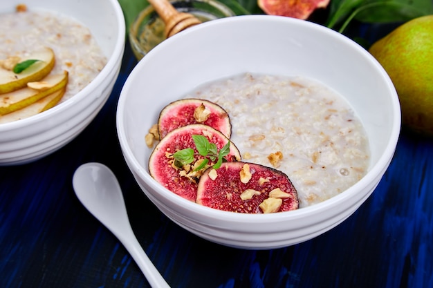 A bowl of porridge with figs slices and walnuts