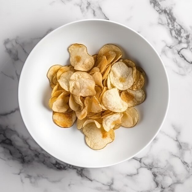 A bowl of potato chips on a marble table.