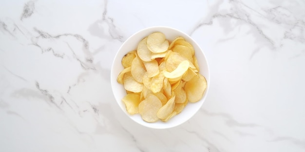 A bowl of potato chips on a marble table