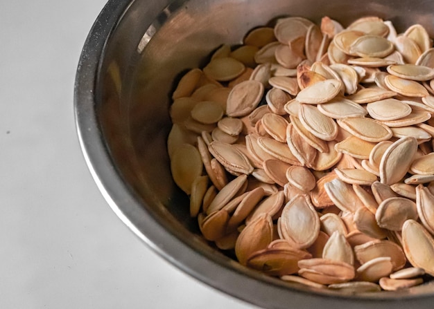 A bowl of pumpkin seeds sits on a white surface A bowl of roasted pumpkin seeds Products with zinc