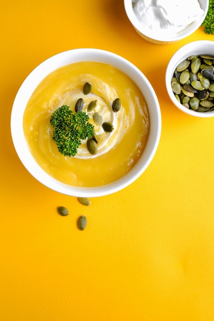 Bowl of pumpkin soup with green leaf