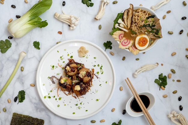 Foto una ciotola di zuppa ramen e un piatto di snack takoyaki