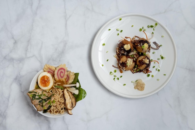 Una ciotola di zuppa ramen e un piatto di snack takoyaki