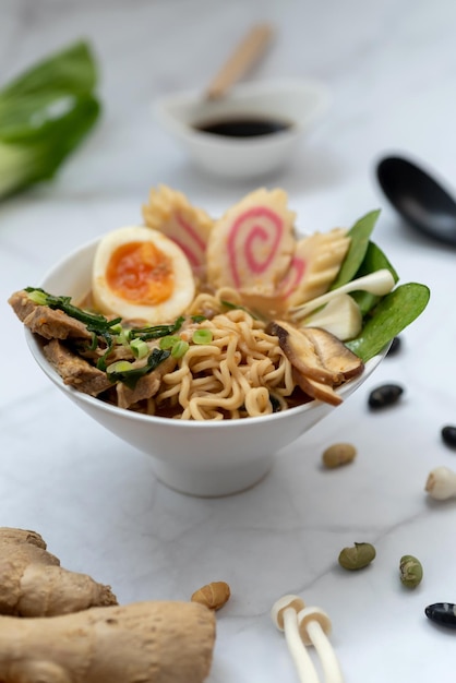 A bowl of ramen soup with all the ingredients over a marble table