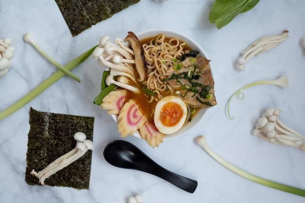 A bowl of ramen soup with all the ingredients over a marble table
