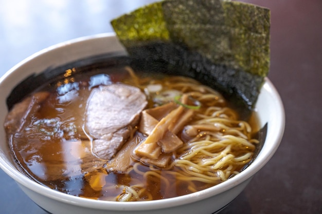 A bowl of ramen with a piece of meat on top