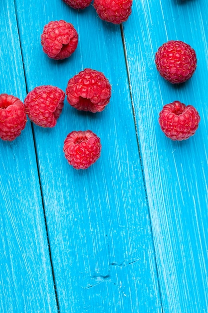 Photo bowl of raspberries on wooden table close up