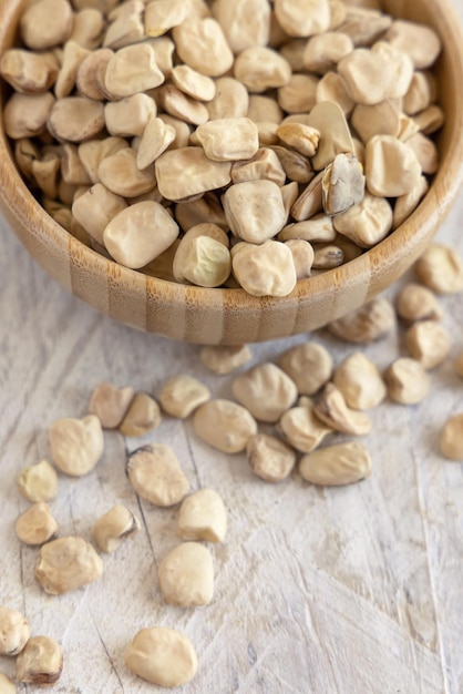 Bowl of raw dry Grass pea close up on wooden table Legumes known in Italy as Cicerchia