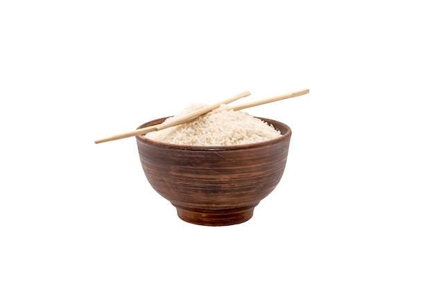 Bowl of raw rice with chopsticks isolated on white