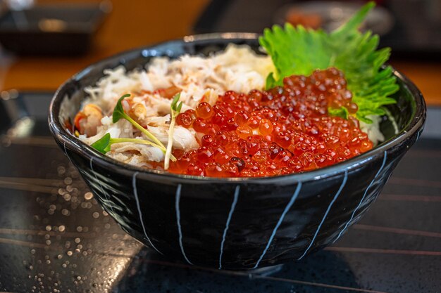 A bowl of red caviar sits on a table.