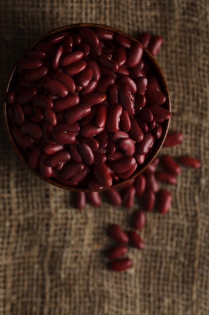 Photo bowl of red haricot beans on sackcloth.