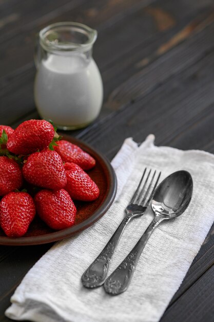 A bowl of red juicy strawberries on rustic wooden table Healthy and diet snack food concept