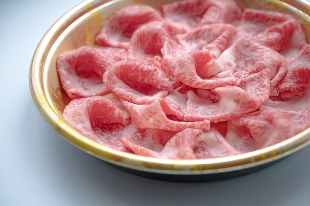 위에 흰색 소스를 얹은 빨간색과 분홍색 음식 한 그릇.