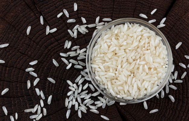 Bowl of rice on black wooden table. Top view