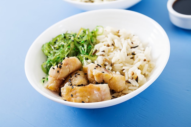 Ciotola di riso, pesce bianco bollito e wakame chuka o insalata di alghe.