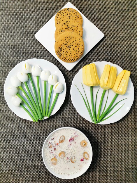 A bowl of rice and flowers are on a table with a bowl of oatmeal and flowers.