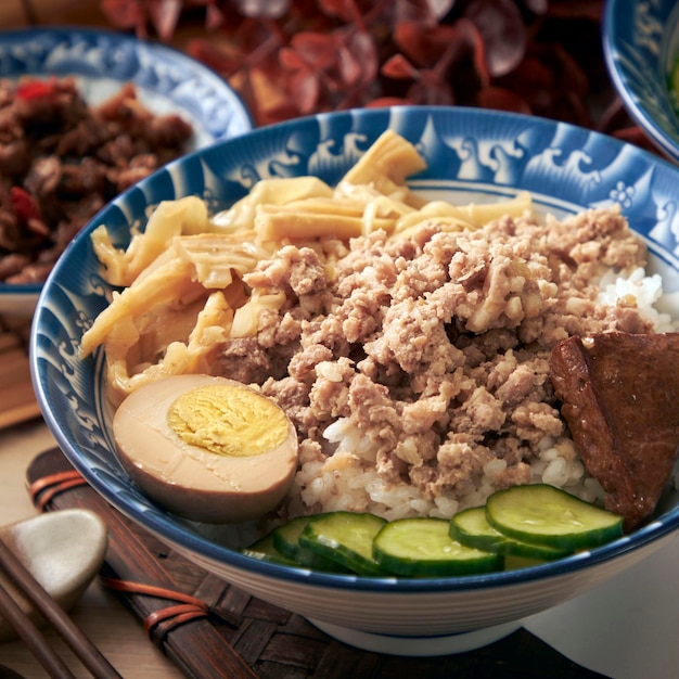 A bowl of rice with meat and egg on it