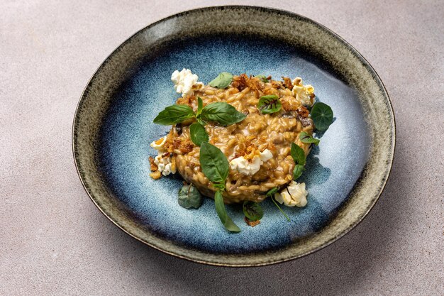 A bowl of risotto with a sprig of basil on top.