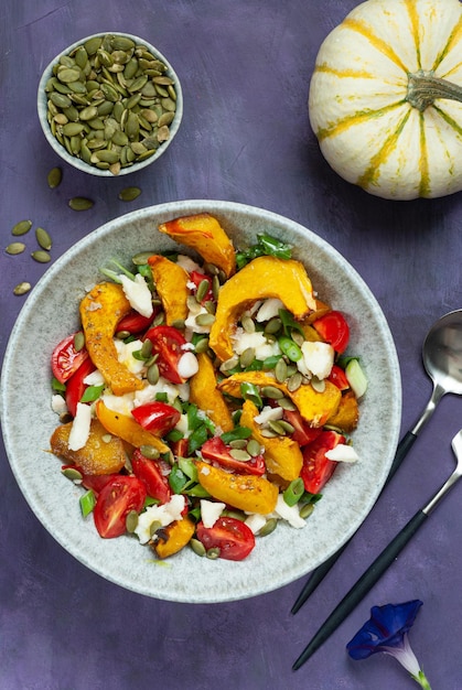 A bowl of roasted squash salad with pumpkin seeds and pumpkin seeds.