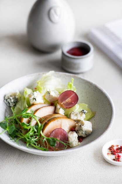 Photo a bowl of salad with blue cheese and a red sauce.