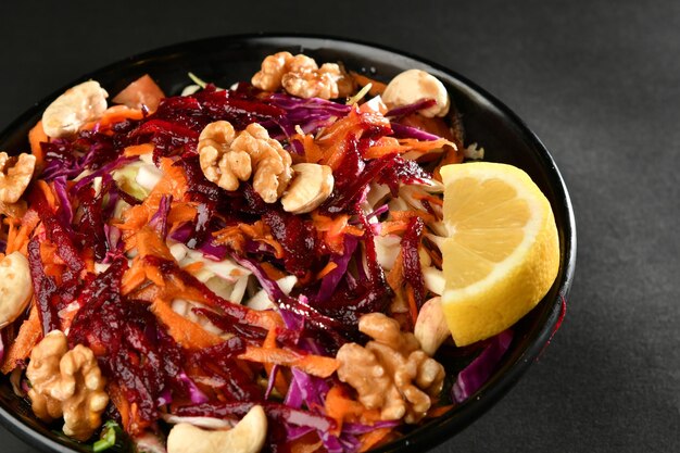 A bowl of salad with a lemon wedge