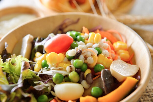 Foto ciotola di insalata con le verdure sulla tavola di legno