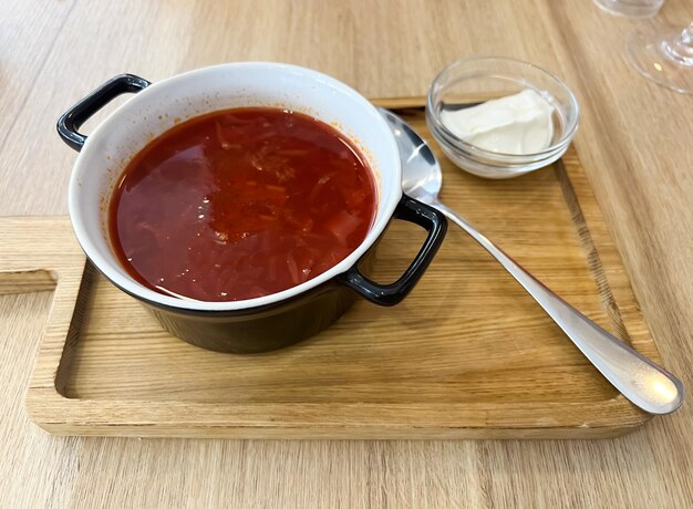 A bowl of sauce with a spoon next to it that says ketchup.