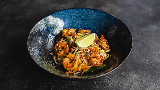 Photo a bowl of shrimp with a lemon wedge on the side