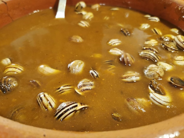 Photo a bowl of snails with a spoon in it