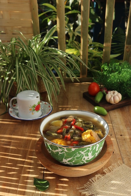 Photo a bowl of soup with a cup of coffee on a table.