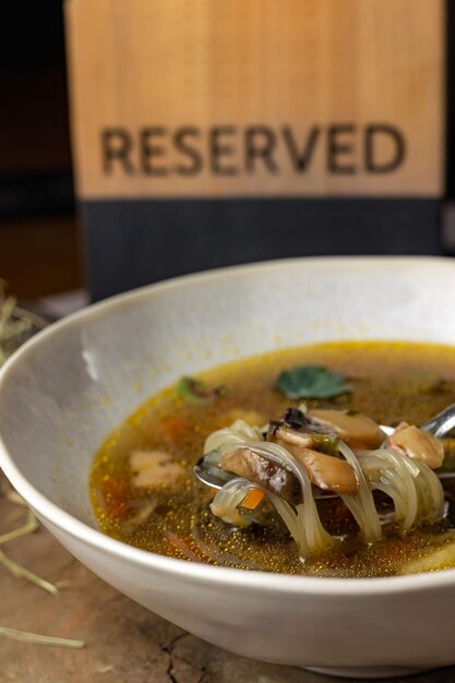 A bowl of soup with a sign that says'noodle soup'on it