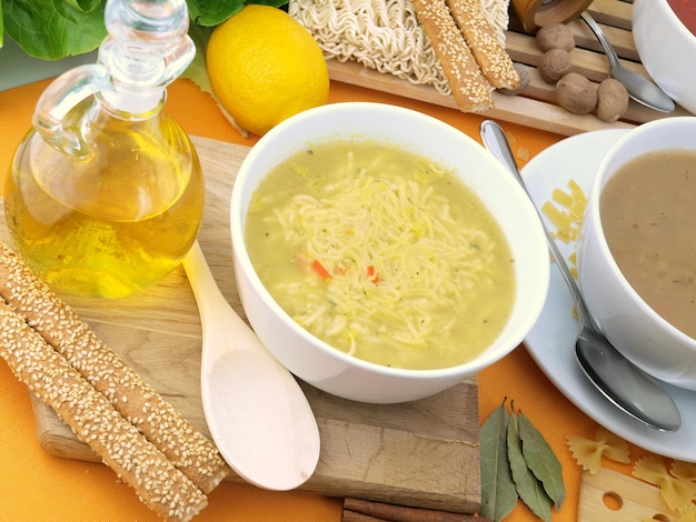 A bowl of soup with a spoon next to it and a bottle of coffee on a table.