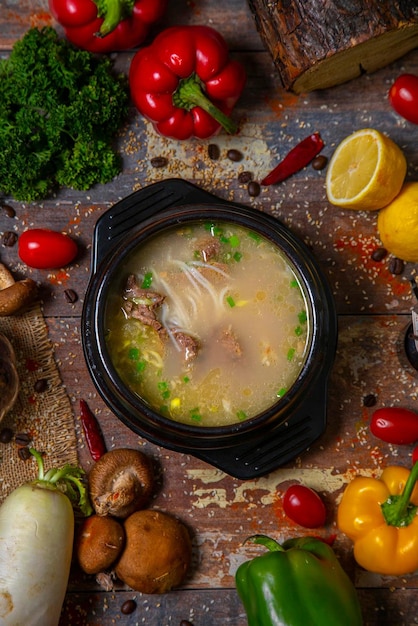 A bowl of soup with vegetables and a bowl of soup with the words " the word bone " on it.