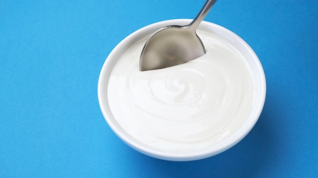 Photo bowl of sour cream, greek yogurt with spoon