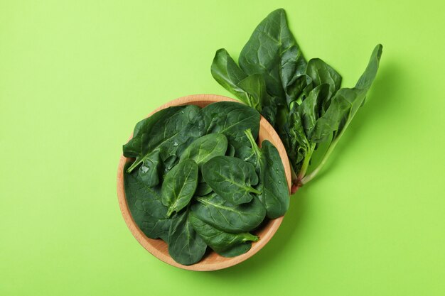 Bowl of spinach leaves on green