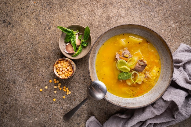 Bowl of split pea soup with chunks of ham and meat top view