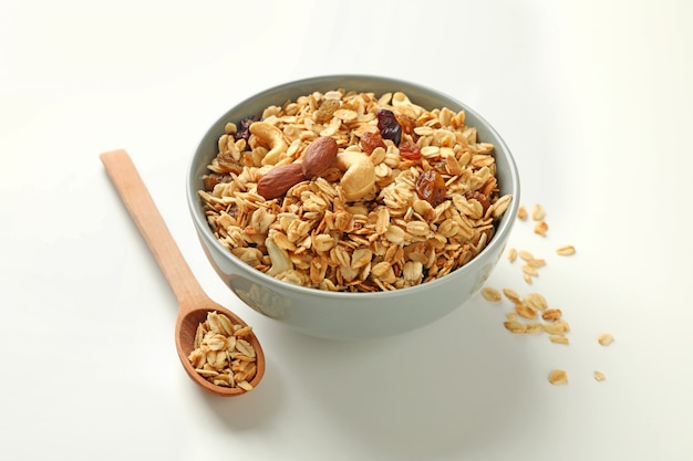 Bowl and spoon with tasty granola isolated