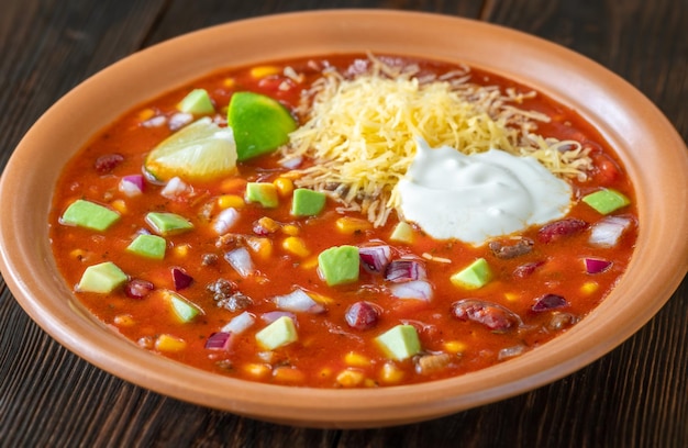 Bowl of taco soup garnished with cheese and sour cream