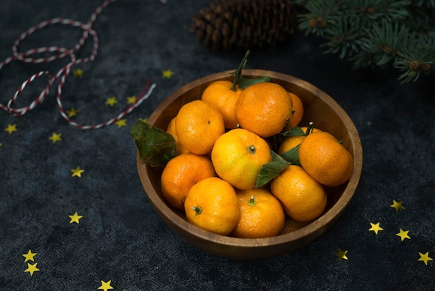 A bowl of tangerines on a dark background