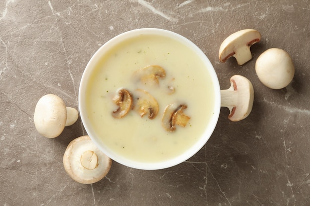 Bowl of tasty mushroom soup on gray