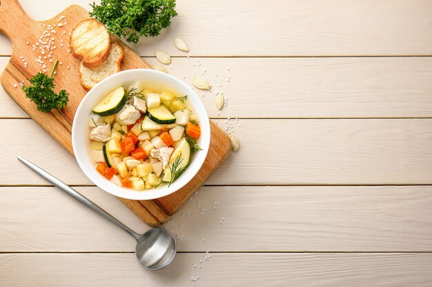 Bowl of tasty soup on wooden table