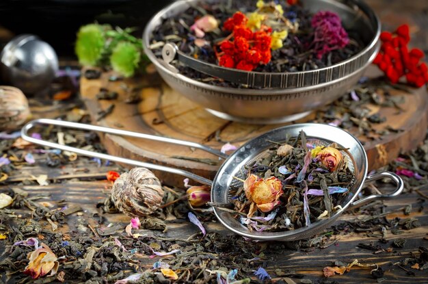 Foto una tazza di tè con sopra un cucchiaio e una ciotola di fiori.