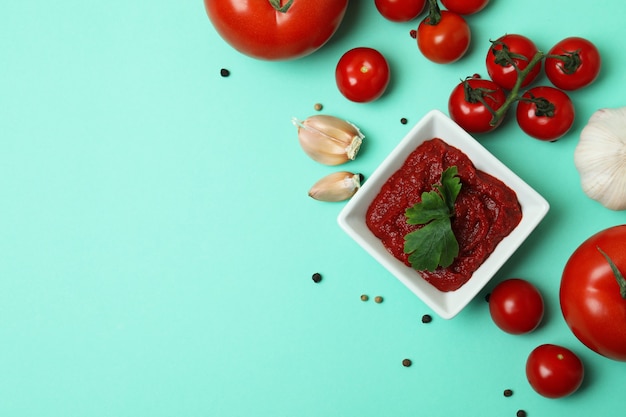 Bowl of tomato paste and ingredients on mint surface