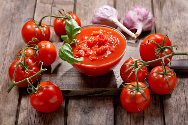 Bowl of tomato sauce with fresh basil and tomatoes