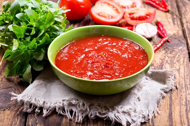 Bowl of tomato sauce on wooden table