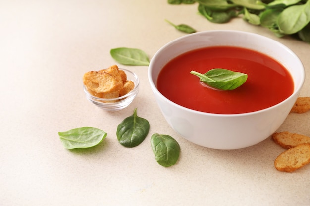 Photo bowl of tomato soup on kitchen table