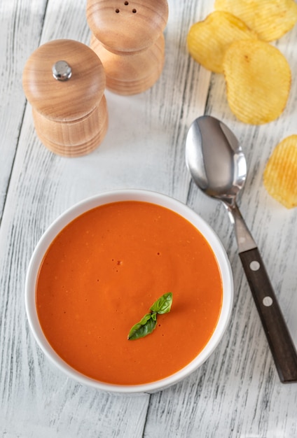 Photo bowl of tomato soup with basil flat lay