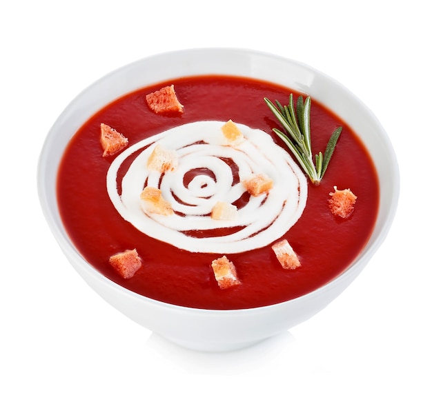 Bowl of tomato soup with croutons closeup isolated on a white background