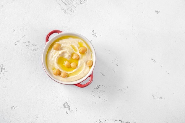 Bowl of traditional hummus on white background