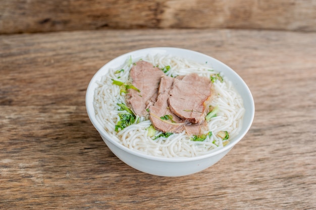 bowl of Traditional Vietnamese beef soup Pho Bo at the dark old wooden background